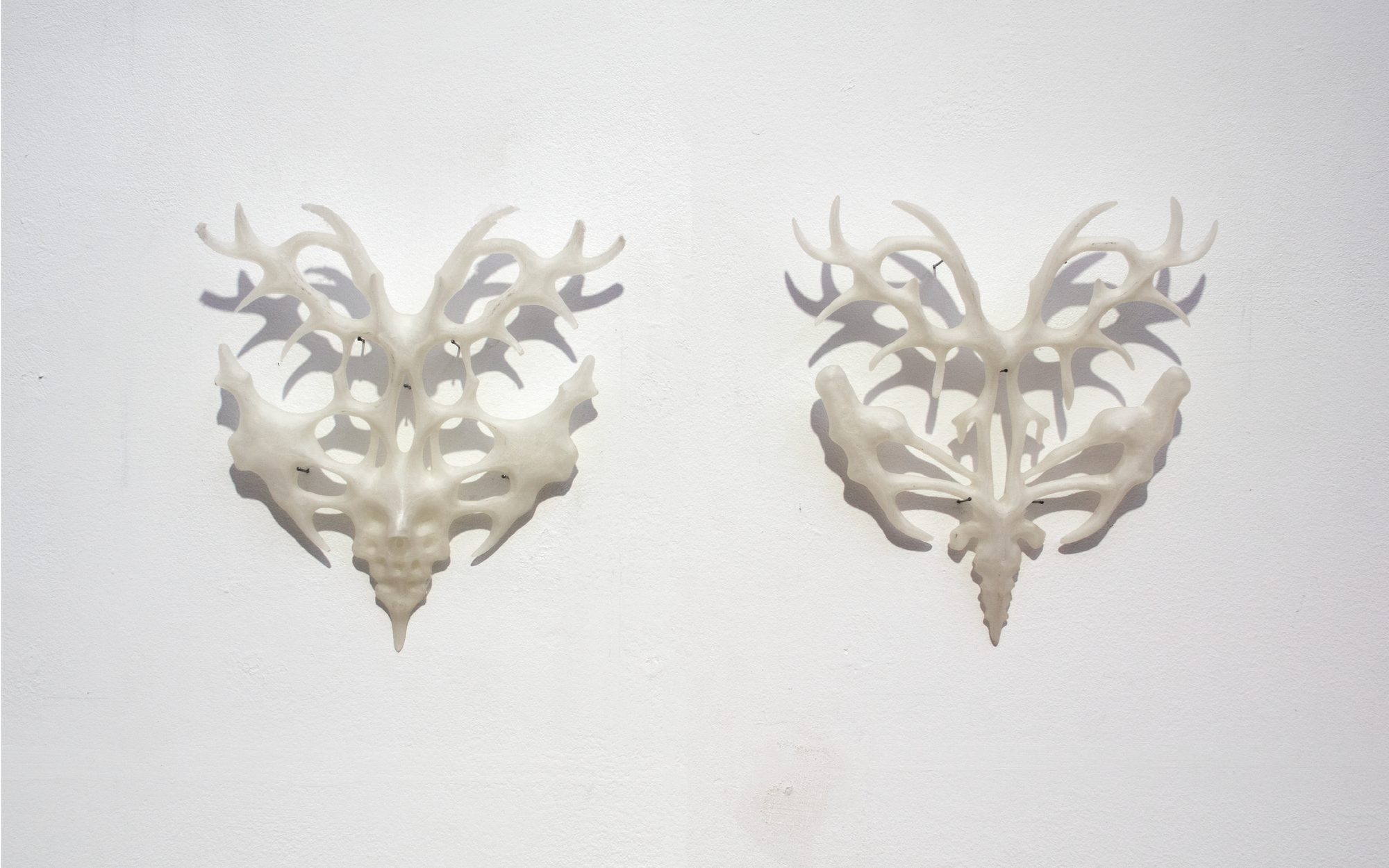 Demain, on reconnaîtra les résistants à leurs déformations salvatrices, two white 3D-printed sculptures on a wall